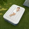 A woman is sleeping on an inflatable mattress on the grass next to a tent. Podgląd zdjęcia produktu