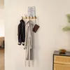 A coat rack with items hanging on it, next to a cabinet. Voir les images du produit