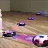 Several hover soccer balls are on a wooden floor, emitting colored light. Podgląd zdjęcia produktu