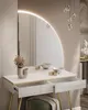 A modern vanity table with a large circular mirror and drawers. Produktbild-Vorschau