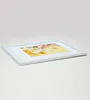 A white picture frame with a photo inside, placed on a white surface. Produktbild-Vorschau