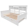 A white wooden daybed with a slatted base and a bookshelf headboard, shown from a diagonal angle against a white background. Náhled obrázku produktu