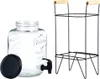 A glass beverage dispenser with a black tap and a black lid, next to a black metal stand with wooden handles. Produktbild-Vorschau