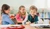 Three young children are sitting at desks in a classroom, engaged in learning activities. Anteprima dell’immagine prodotto