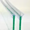 Close-up view of two clear plastic shower door seals attached to green glass panels, with water droplets on the seals. Podgląd zdjęcia produktu