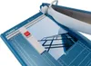 A close-up view of a blue paper guillotine with a photograph of a modern building placed on it. Anteprima dell’immagine prodotto