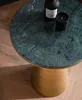 A close-up shot of a round marble side table with a gold base, featuring a black bottle and a black candle on its surface. Produktbild-Vorschau