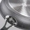 Close-up view of the underside of a frying pan, showing the textured surface and handle attachment. Náhled obrázku produktu