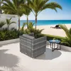 An outdoor patio scene with a rattan armchair, a small side table with drinks, and a beach in the background. Produktbild-Vorschau