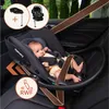 A baby is sitting in a car seat in the back seat of a car. Náhľad obrázku produktu