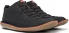 A pair of black Camper shoes with brown soles and orange trim.