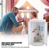 A father and daughter are playing with dolls and a dollhouse, with a miniature shower room in the foreground. Voir les images du produit