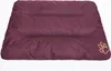 A burgundy dog bed with a paw print logo in the corner, shown from a slightly elevated front-facing angle on a white background. Produktbild-Vorschau