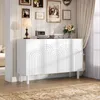 A white sideboard with decorative arched doors is placed in a well-lit room with a rug and framed pictures on the wall. Voir les images du produit