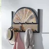 A wall-mounted coat rack with a decorative wooden panel and woven rattan. Produktbild-Vorschau