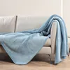 A blue blanket draped over a sofa. Anteprima dell’immagine prodotto