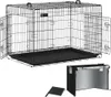 A black wire dog crate with a black plastic tray is shown against a white background. A smaller black accessory, possibly a cover or mat, is placed in the foreground. Produktbild-Vorschau