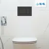 A toilet flush plate and part of a toilet in a bathroom. Produktbild-Vorschau