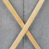 A close-up view of two crossed wooden slats against a textured gray fabric background. Náhled obrázku produktu