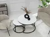 A modern living room scene with a nesting coffee table set, a chair, and a sofa. Náhľad obrázku produktu