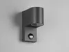 A modern gray wall light with a motion sensor is mounted on a light gray wall. Produktbild-Vorschau