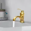A close-up shot of a brass faucet in a bathroom sink, with water running. Podgląd zdjęcia produktu