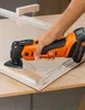 A person is using an oscillating multi-tool to work on a wooden frame. Náhľad obrázku produktu