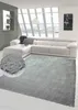 A modern living room with a white sectional sofa and a gray shaggy rug. Produktbild-Vorschau