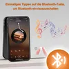 A smartphone displaying a music app is placed next to a mirror with a finger touching a button. Musical notes are depicted in the background, and a Bluetooth symbol is illuminated. Produktbild-Vorschau