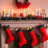 A festive Christmas fireplace scene with stockings hung and candles lit on the mantelpiece. Produktbild-Vorschau