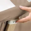 A close-up shot of a hand adjusting a clip on a beige baby bed. Náhľad obrázku produktu