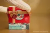 Hands holding a Christmas advent calendar with a winter village scene. Anteprima dell’immagine prodotto