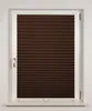 A close-up view of a dark brown pleated window blind installed in a white window frame. Produktbild-Vorschau