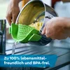 Hands are draining pasta from a pot using a green silicone strainer attachment over a sink. Produktbild-Vorschau