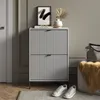 A hallway or entryway scene featuring a shoe cabinet, artwork, and decorative items. Podgląd zdjęcia produktu