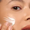 A close-up of a person's face with cream being applied. Náhľad obrázku produktu