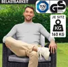A man is sitting on a polyrattan garden chair in a garden setting. Produktbild-Vorschau