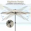 A beige patio umbrella shown in a tilted position against a beach and ocean background. Náhled obrázku produktu
