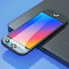 A screen protector is shown placed on a Nintendo Switch console, which is resting on a textured surface with a blue background. Produktbild-Vorschau
