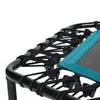 A close-up view of the edge of a trampoline, showing the black frame and the black elastic cords attaching the mat. Voir les images du produit