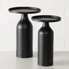 Two black side tables are shown against a white brick wall and a light gray surface. Produktbild-Vorschau