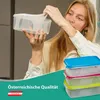 A woman is holding two clear plastic food storage containers, one inside the other. Below, a stack of three similar containers with colored lids (blue, pink, and green) is visible. The bottom of the image features a teal banner with text and a small flag. Produktbild-Vorschau