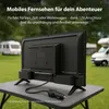 A small TV is set up on a portable table outdoors, with RVs in the background. Produktbild-Vorschau