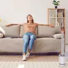 A woman relaxing on a couch with a fan in the foreground. Podgląd zdjęcia produktu