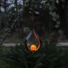 A decorative lantern hanging from a tree branch at dusk. Produktbild-Vorschau