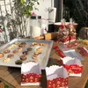 A table set up for baking Christmas cookies, with cookies on a baking sheet, ingredients, and packaging for the cookies. Produktbild-Vorschau