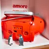 A red Blaupunkt boombox with two small penguin figurines in front of it, placed on a shelf. Produktbild-Vorschau
