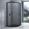 A modern black shower cabin with a curved glass door, set against a concrete wall and a window with a mountain landscape view. Produktbild-Vorschau