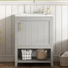 A light gray vanity cabinet with a white sink and a gold handle, set against a white paneled wall. Voir les images du produit