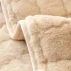 A close-up view of a soft, textured beige fabric, likely a blanket or sofa cover, with a quilted pattern. Náhled obrázku produktu